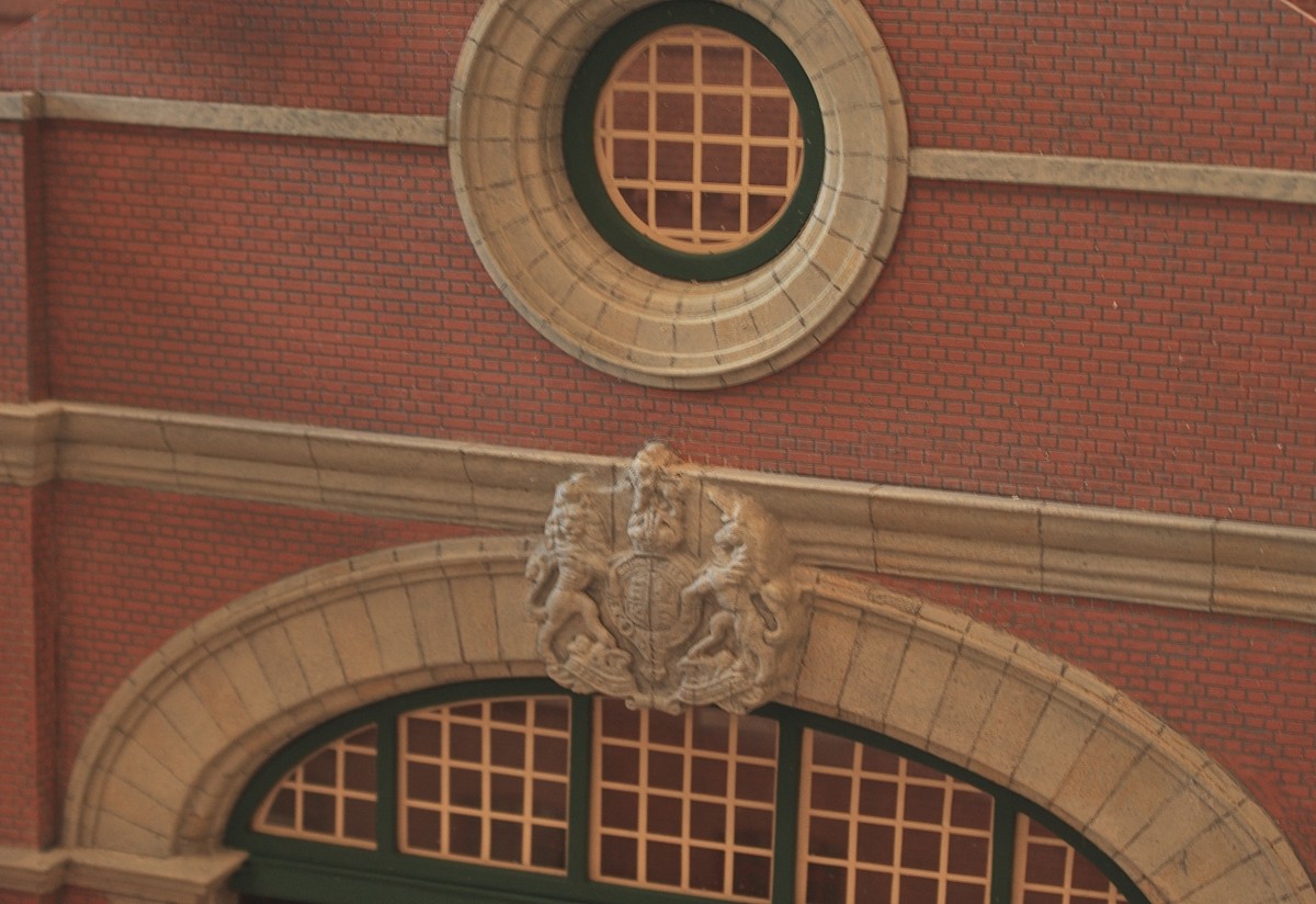 Stone cornices and carved keystone detail. To keep to the generic nature of the station, the coat of arms is simply the royal emblem instead of that of a railway company. The decorative window portal in the gable above was turned to the same profile as the arch below, and the panelled glazing is laminated from plastikard profiles.