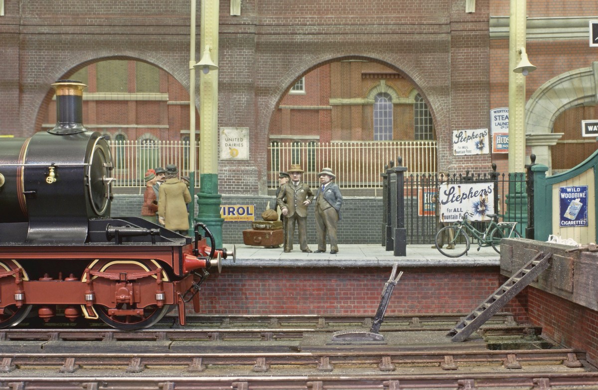 Detail from terminus interior, with platform end clutter, and a parallel one layer backscene at reduced scale. The standing passengers populating the concourse are new releases from Andy Stadden and these additions to his range can now be viewed by clicking the link below. Original by Steve Flint/Railway Modeller.
